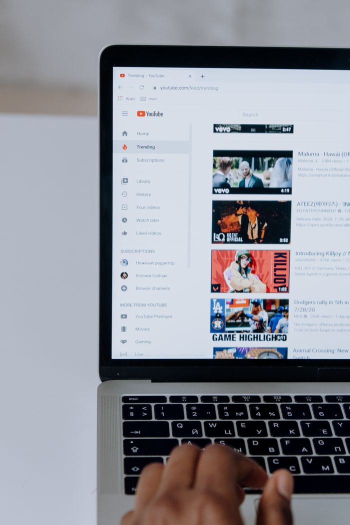 A person browsing YouTube videos on a laptop, highlighting modern technology and online content.